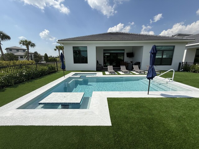 view of swimming pool featuring a yard and an in ground hot tub