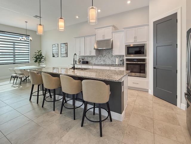 kitchen with oven, sink, hanging light fixtures, and white cabinets