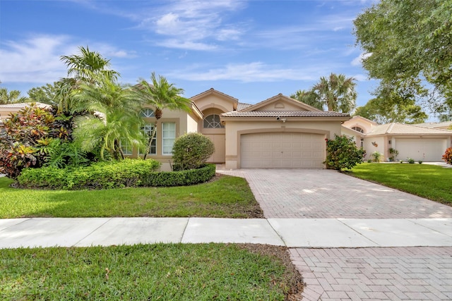 mediterranean / spanish home with a garage and a front lawn