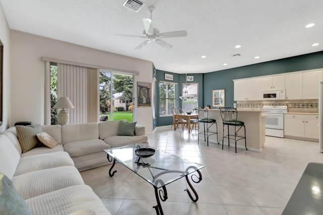 living room with light tile patterned floors and ceiling fan