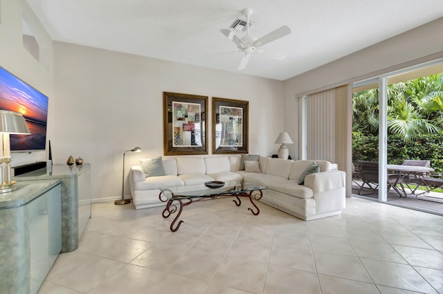 living room with a textured ceiling, ceiling fan, and light tile patterned flooring