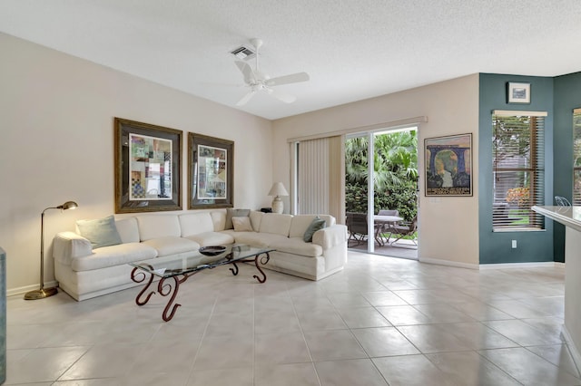 tiled living room featuring ceiling fan and a textured ceiling