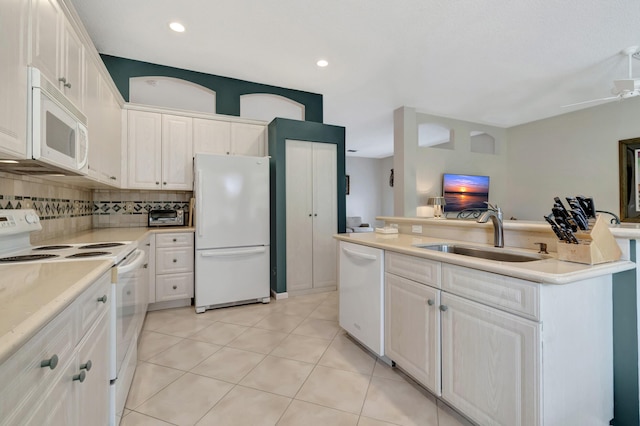 kitchen featuring white cabinetry, sink, white appliances, and backsplash