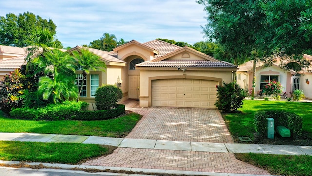 mediterranean / spanish home with a garage and a front yard