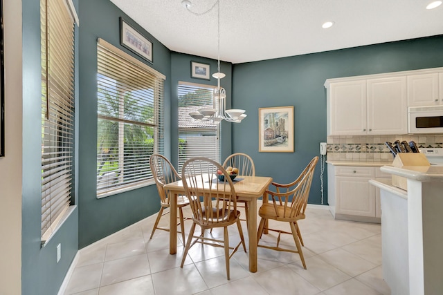 tiled dining space with an inviting chandelier and a textured ceiling