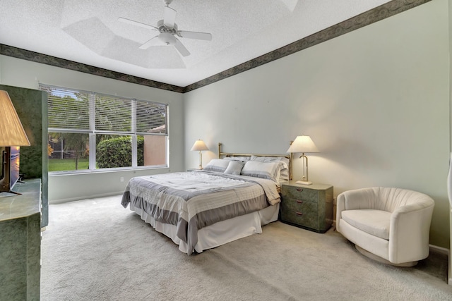 carpeted bedroom with ceiling fan and a textured ceiling