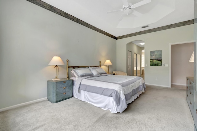 carpeted bedroom featuring ceiling fan, connected bathroom, a raised ceiling, and a closet