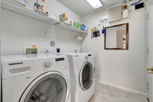 laundry area featuring independent washer and dryer, a textured ceiling, and light tile patterned flooring