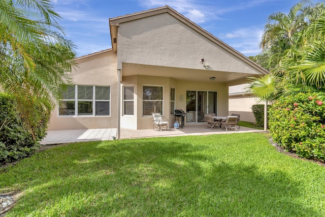 rear view of property with a patio and a lawn