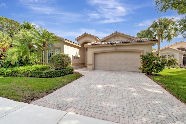 mediterranean / spanish-style house featuring a garage and a front lawn