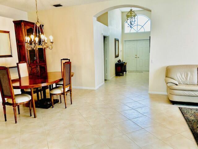 tiled dining room with a notable chandelier