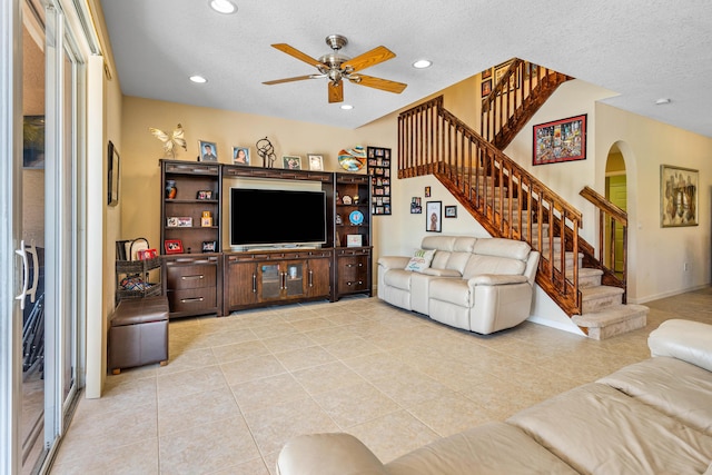 tiled living room with ceiling fan and a textured ceiling