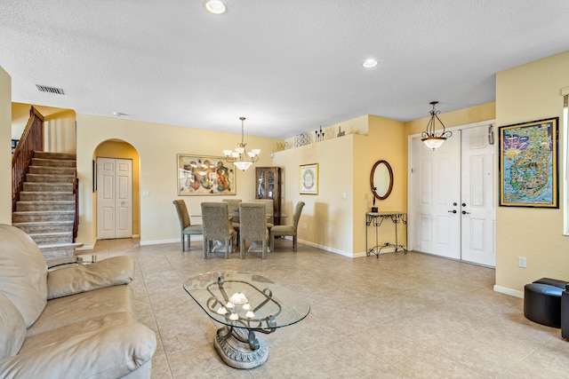 living room featuring an inviting chandelier and a textured ceiling