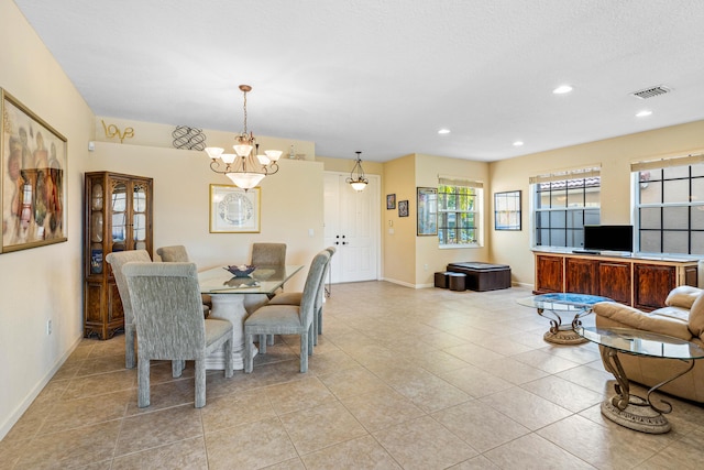 tiled dining space with a chandelier