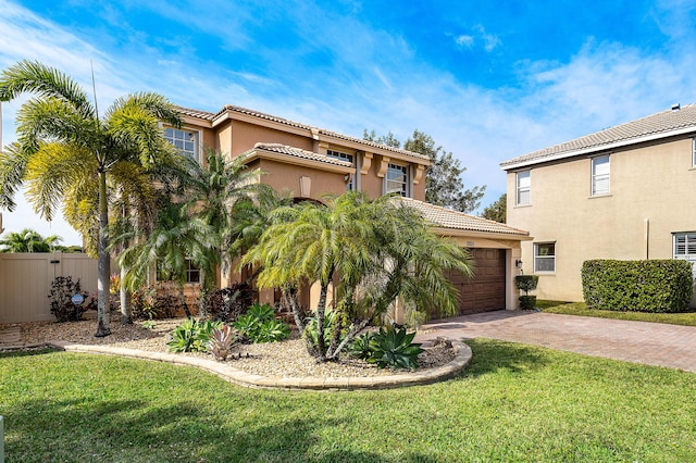 mediterranean / spanish-style house featuring a garage and a front yard