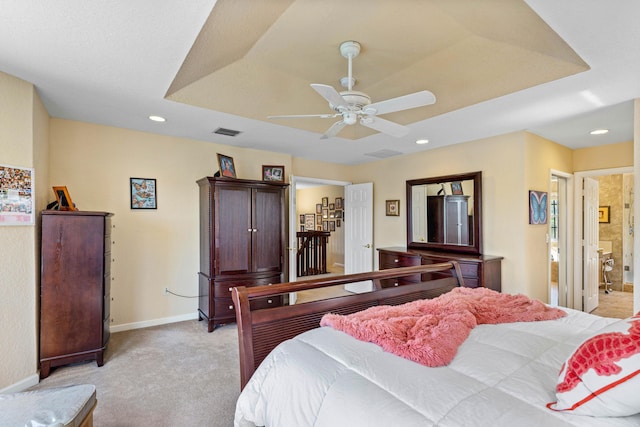 bedroom featuring ceiling fan, light colored carpet, and a tray ceiling