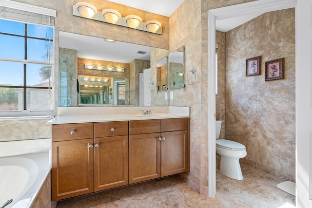 bathroom featuring vanity, tile patterned flooring, a bathing tub, and toilet