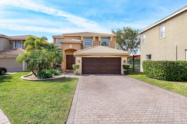 mediterranean / spanish home featuring a garage and a front yard