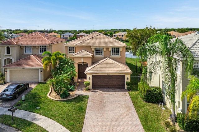 mediterranean / spanish home featuring a garage and a front lawn