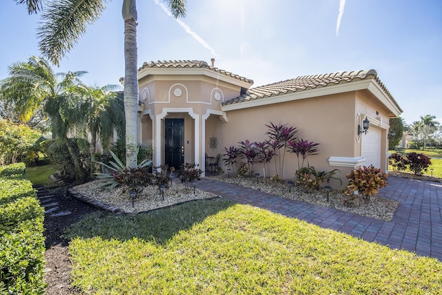 view of front of property with a garage and a front lawn