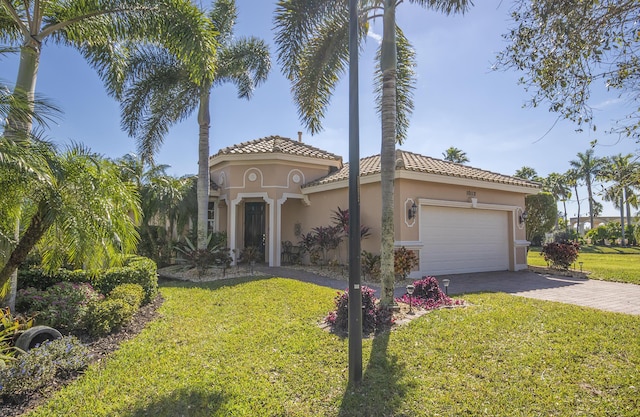 mediterranean / spanish house featuring a garage and a front lawn