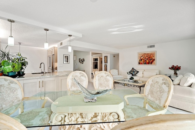 tiled dining space featuring sink and a textured ceiling