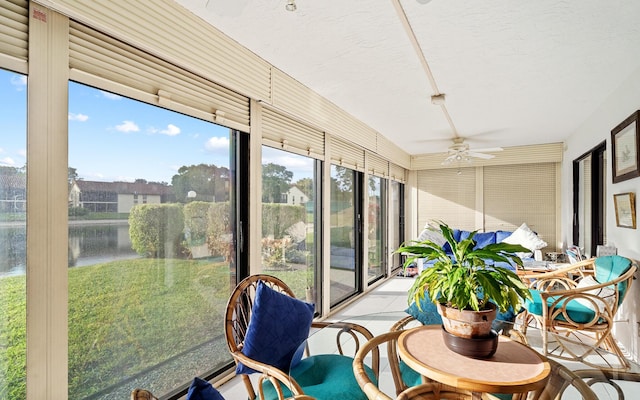 sunroom with a water view and ceiling fan