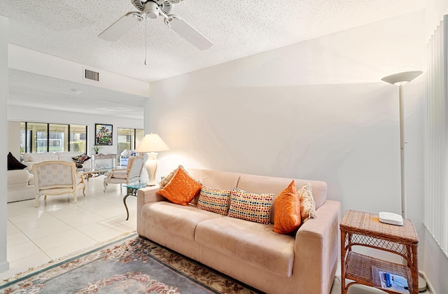 tiled living room featuring ceiling fan and a textured ceiling