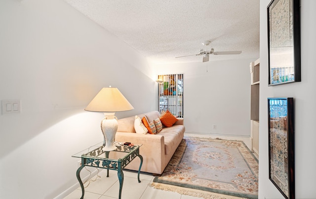 living room featuring light tile patterned flooring, ceiling fan, and a textured ceiling