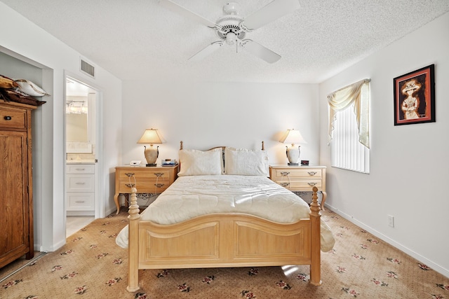 carpeted bedroom featuring ceiling fan, a textured ceiling, and ensuite bath