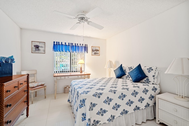 bedroom with light tile patterned flooring, ceiling fan, and a textured ceiling