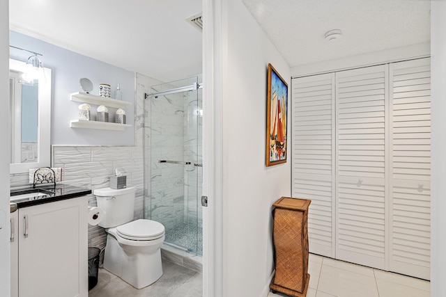 bathroom with tile walls, vanity, an enclosed shower, toilet, and tile patterned floors