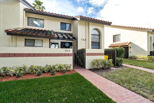 mediterranean / spanish-style home with a front lawn