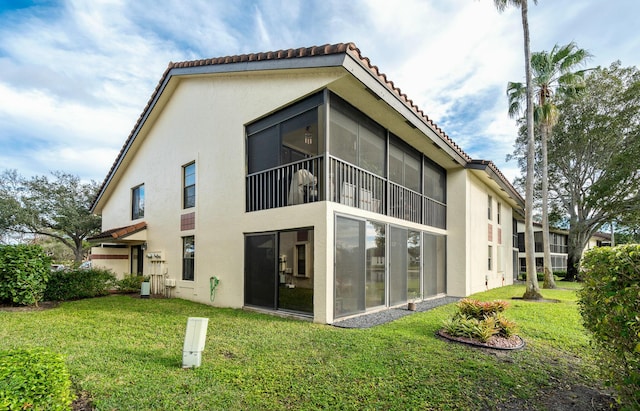 rear view of property featuring a lawn