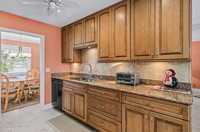 kitchen featuring sink, dishwasher, stone counters, tasteful backsplash, and ceiling fan with notable chandelier