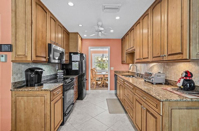 kitchen featuring sink, light stone counters, light tile patterned floors, ceiling fan, and black appliances