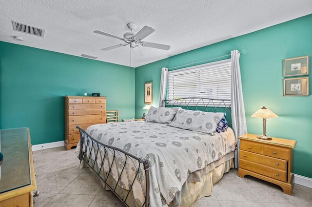 bedroom with ceiling fan and a textured ceiling