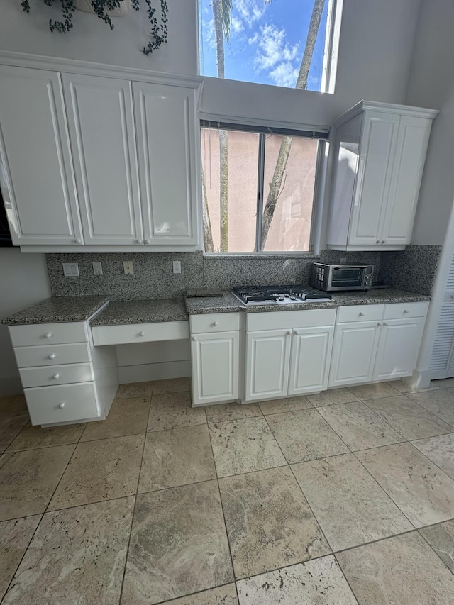 kitchen with white cabinetry, plenty of natural light, stainless steel gas cooktop, and tasteful backsplash