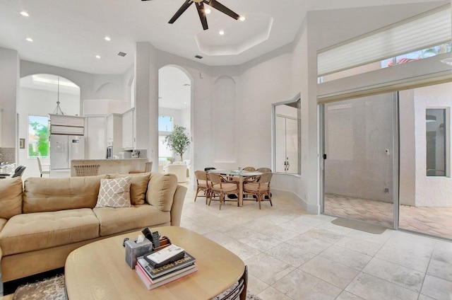 living room with light tile patterned floors, a towering ceiling, and ceiling fan