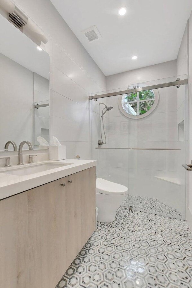 bathroom featuring vanity, an enclosed shower, and toilet