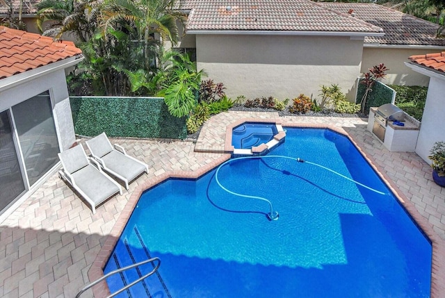 view of swimming pool with area for grilling and an in ground hot tub