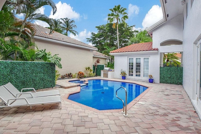 view of swimming pool with an in ground hot tub, a patio, and french doors