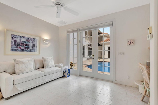 tiled living room with french doors and ceiling fan