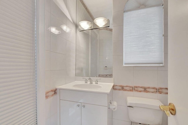 bathroom featuring tile walls, vanity, and toilet