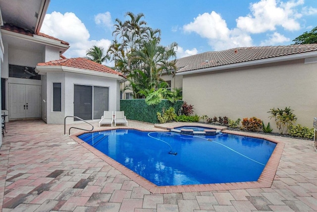 view of swimming pool with a patio area and an in ground hot tub