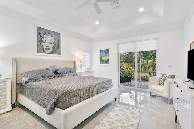 bedroom with access to exterior, a tray ceiling, and ceiling fan