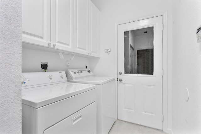 washroom with cabinets and washer and clothes dryer