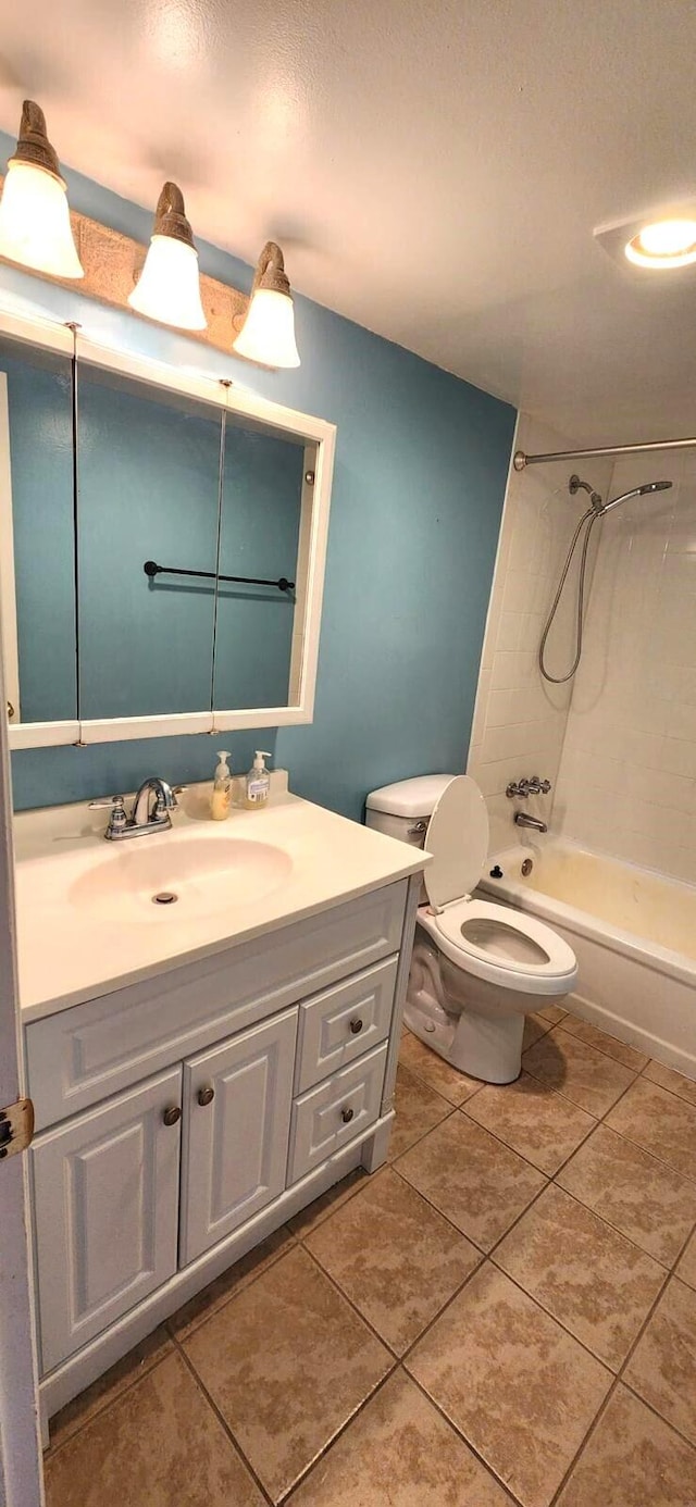 full bathroom featuring tiled shower / bath, vanity, toilet, and tile patterned flooring