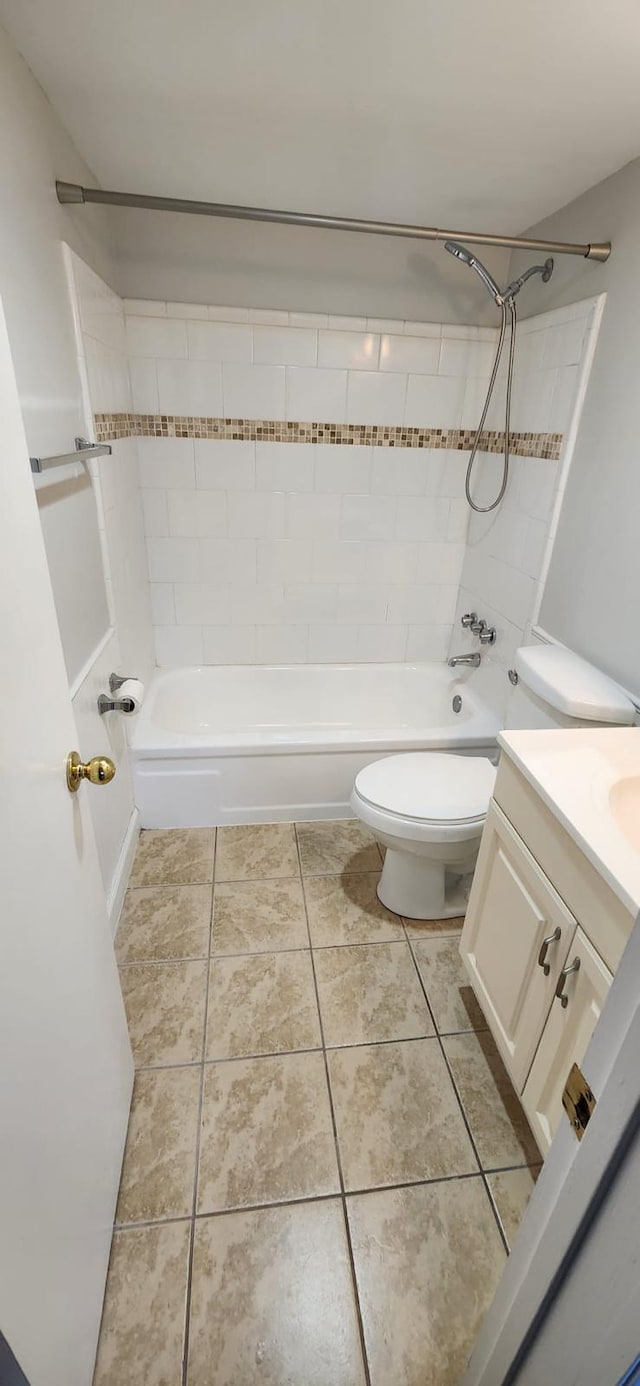 full bathroom featuring tiled shower / bath, vanity, toilet, and tile patterned flooring