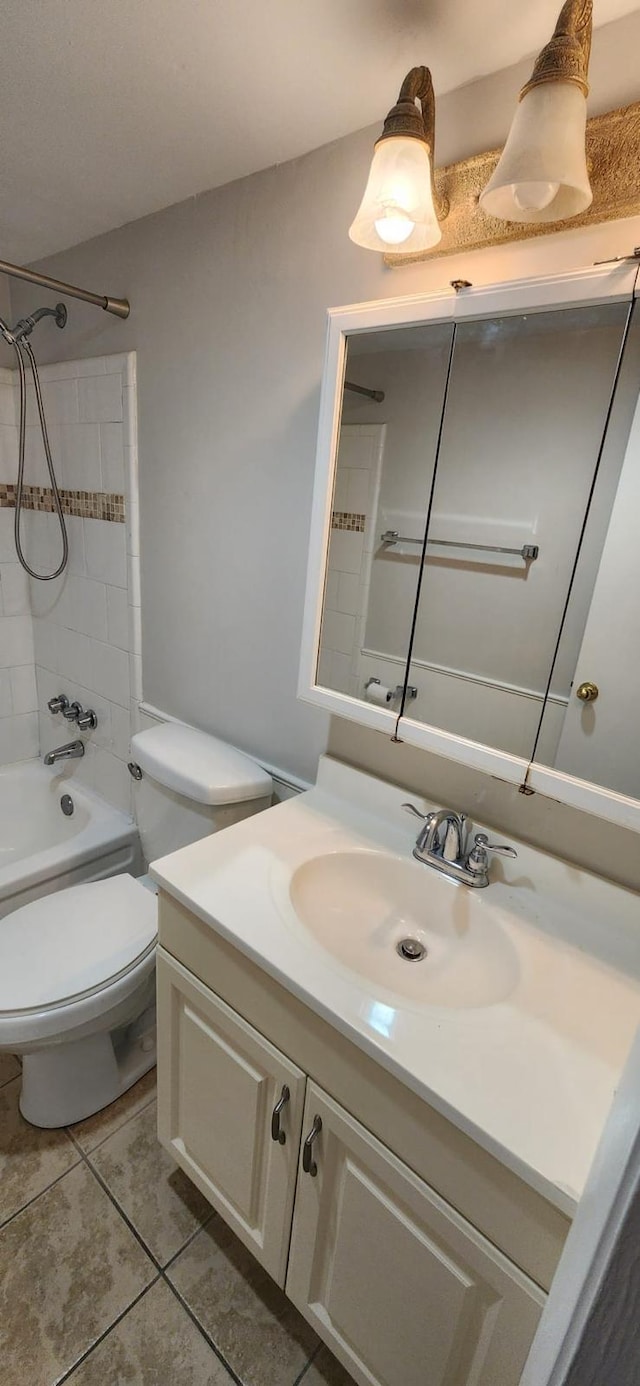 full bathroom featuring tile patterned floors, toilet, tiled shower / bath combo, and vanity